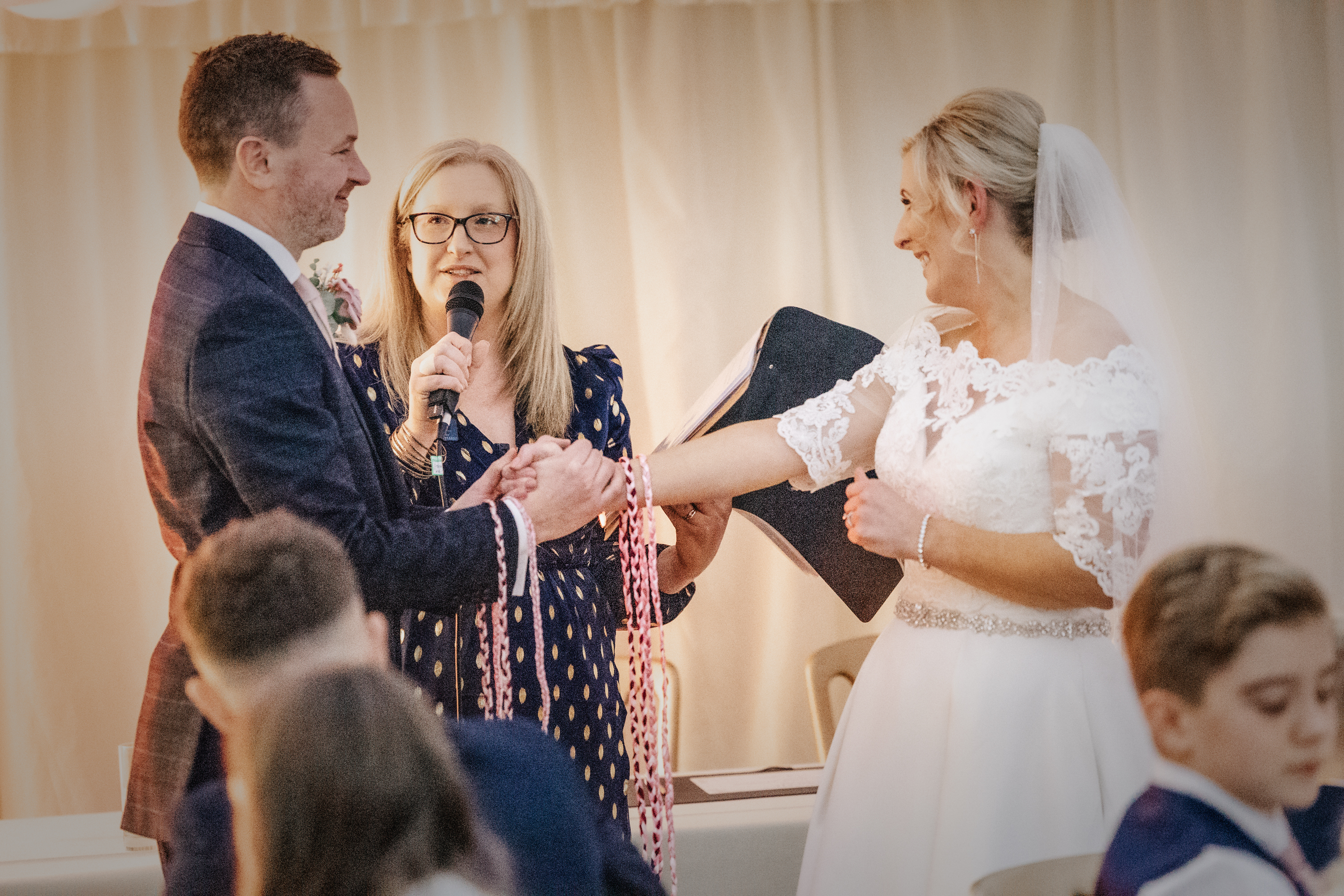 Deb Reed Celebrant Essex Colchester officiating Rachael and Lukes wedding, smiling at their son.